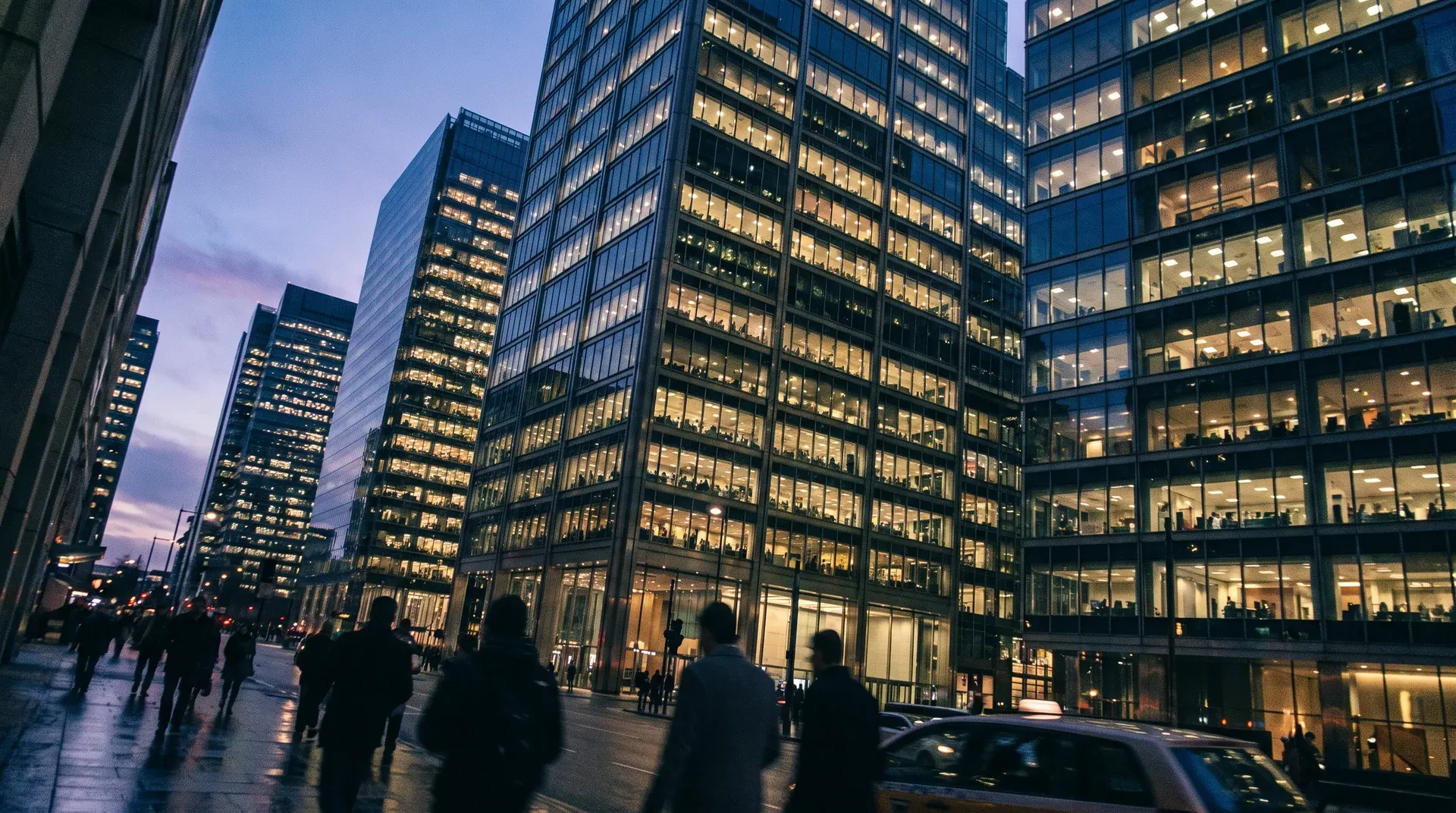 Verlichte kantoorgebouwen in financieel district bij schemering met voetgangers op straat