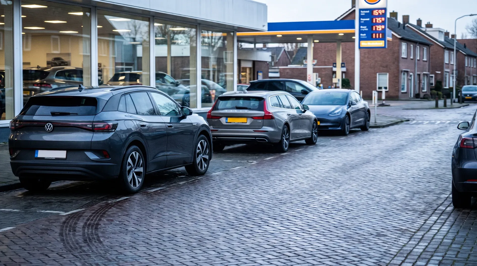 Rij geparkeerde auto's op kasseienplein voor autohandelaar met showroom en benzinestation