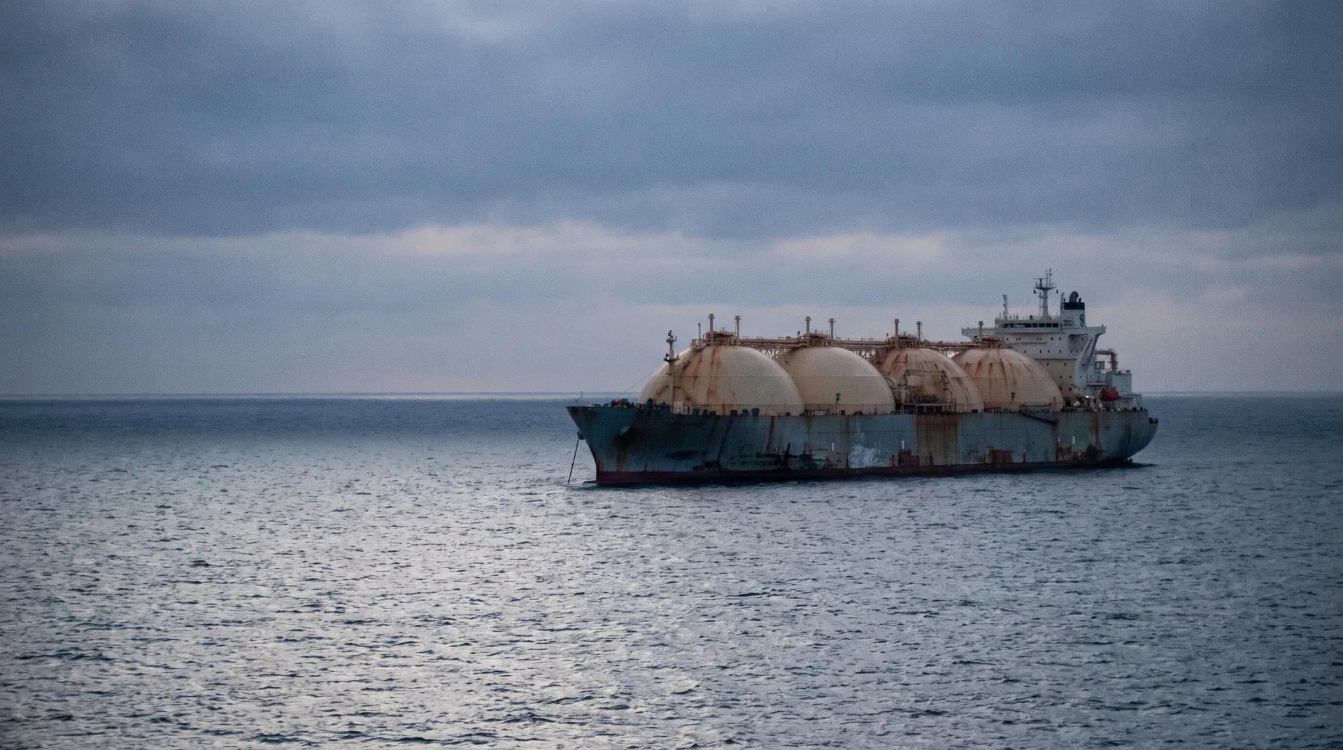 LNG-tanker met vier grote gastanks op open zee onder bewolkte hemel