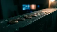 Rij bitcoin-munten op donkere ondergrond met blurred lichten op achtergrond