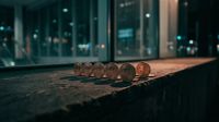 Rij Bitcoin-munten op straat met nachtelijk stadssilhouet op achtergrond