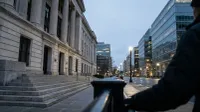 Verlichte financiële wijk bij schemering met klassieke en moderne gebouwen langs brede straat