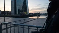 Modern glazen kantoorgebouw aan waterfront bij zonsopgang, spiegeling in stil water, stedelijke skyline op achtergrond