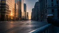 Verlaten stadstraat met kantoorgebouwen bij zonsopgang, gouden licht op glazen gevels
