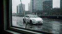 Natte stadstraat 's nachts met zwarte taxi in focus, verkeerslichten, andere voertuigen en neonborden op achtergrond