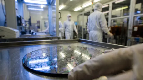 Waferproductie in cleanroom: siliciumwafers op transportband met technicians in beschermkledij op achtergrond