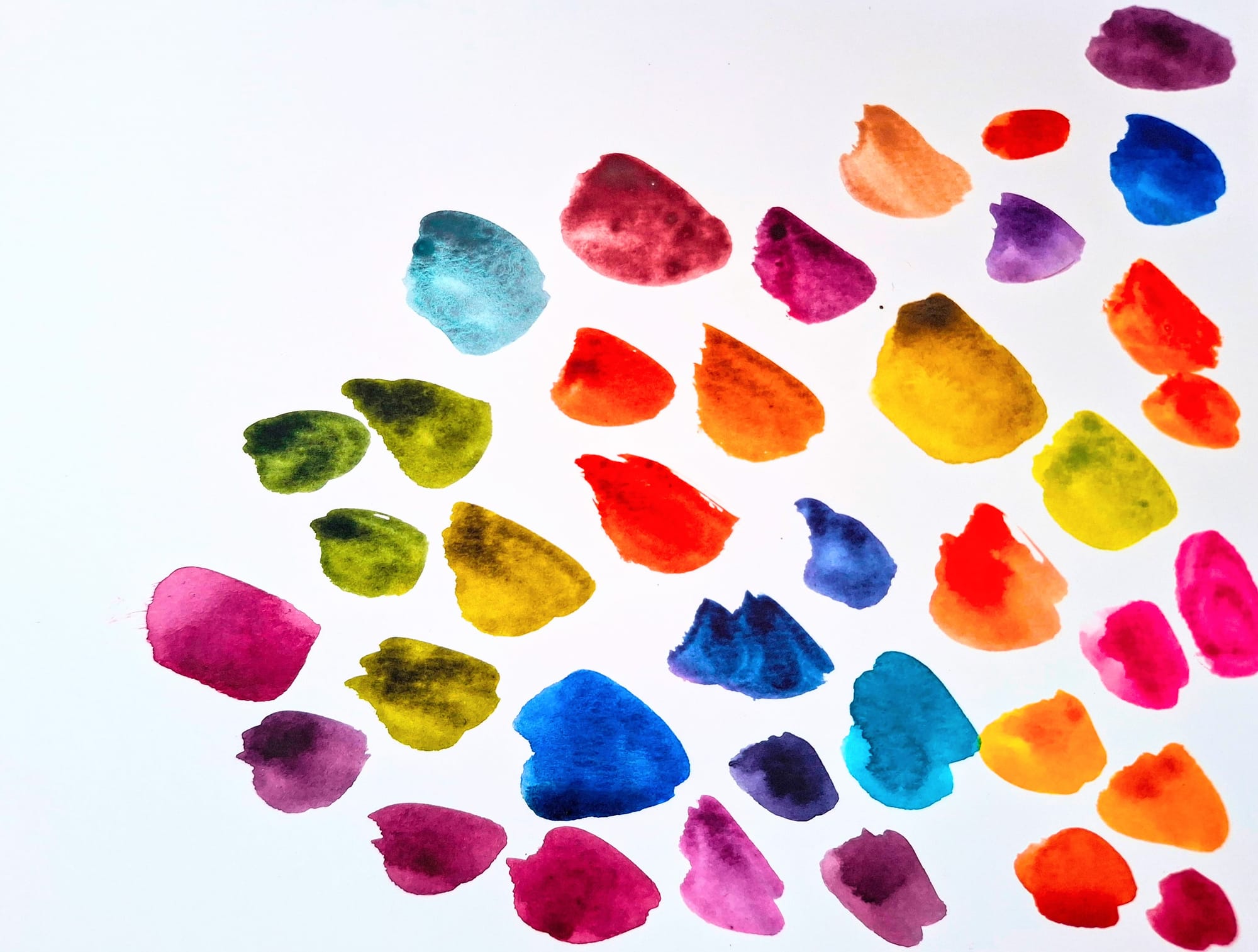 Bright watercolour colour swatches in greens, oranges, blues and pinks in a random pattern on draft paper by emma bolton.