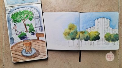 Watercolour sketch of a coffee on a wooden table. A more confident watercolour sketch of an apartment block surrounded by a blue sky and green trees in Jaén, four years later. 