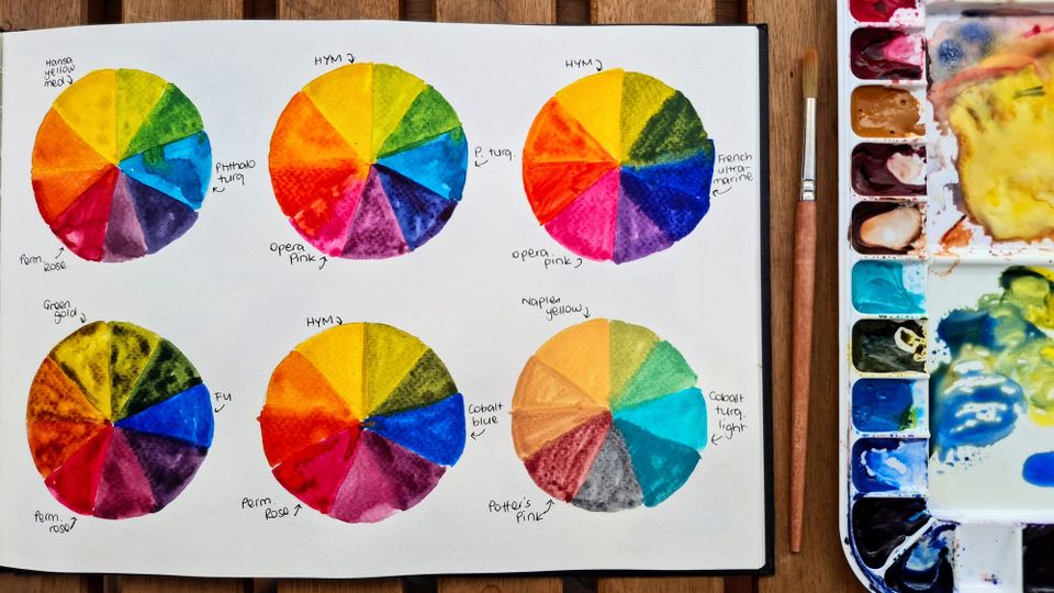 Six colour wheels using different combinations of pink, yellow and blue watercolours by emma bolton. Watercolor brush and palette.