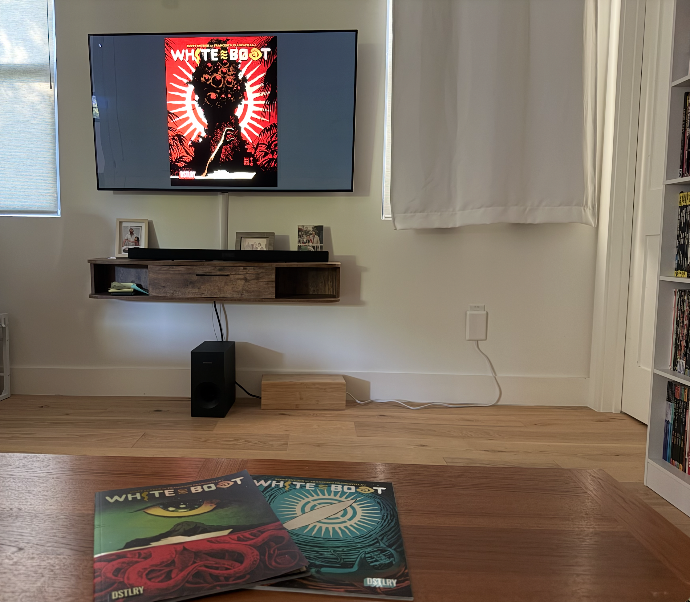Photograph of comic series White Boat shown on a large TV screen and in print on a table.