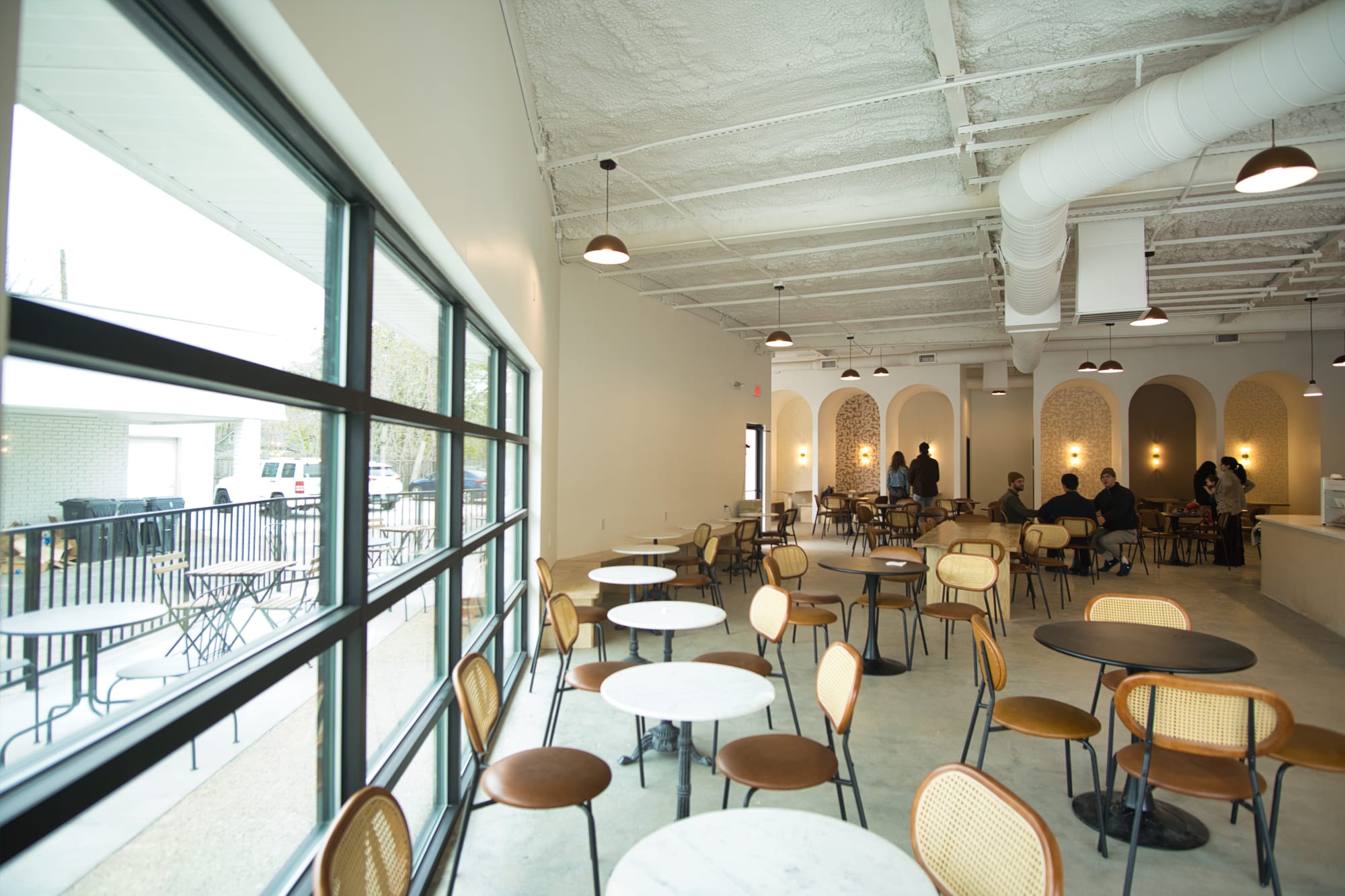 Inside For Keeps Coffee House in Waco, with the arched seating booths in the backdrop