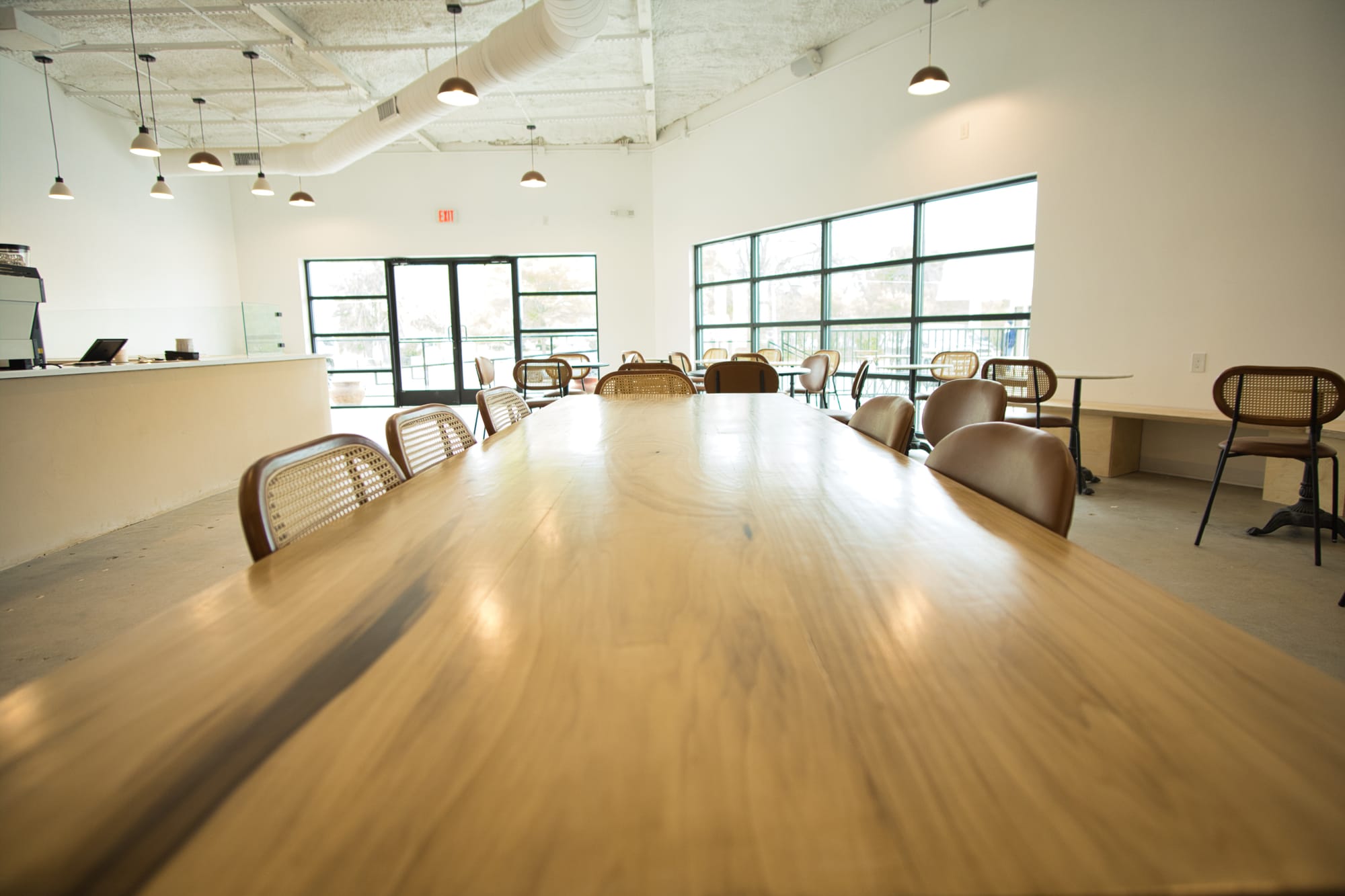 A long table with wood grains at For Keeps Coffee Shop in Waco, TX; it was made by a local carpenter