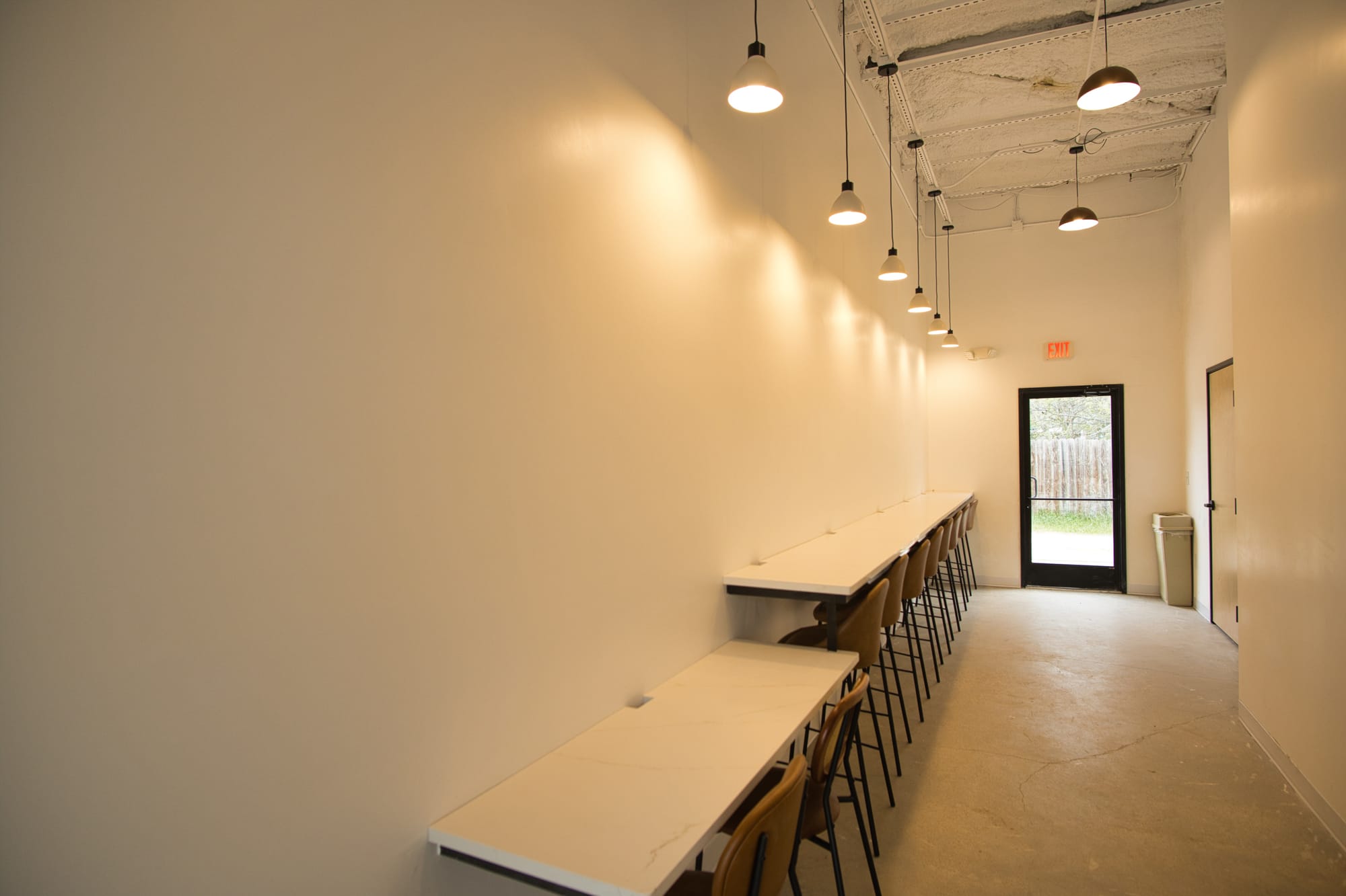 Raised bar seating area with cutouts for power cables at local Waco coffee shop called For Keeps