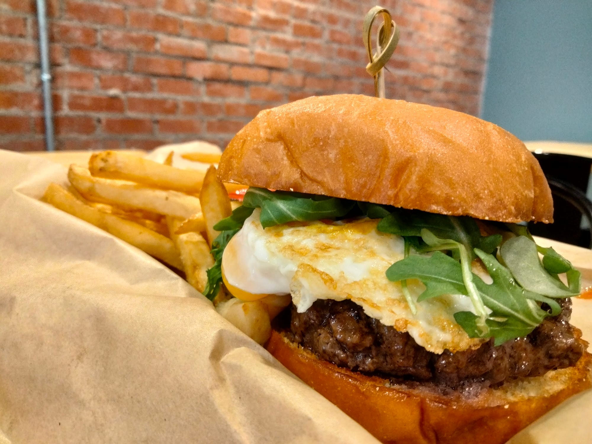 The Golden Calf Burger at Revival Eastside Eatery with burger, egg, arugula and fries