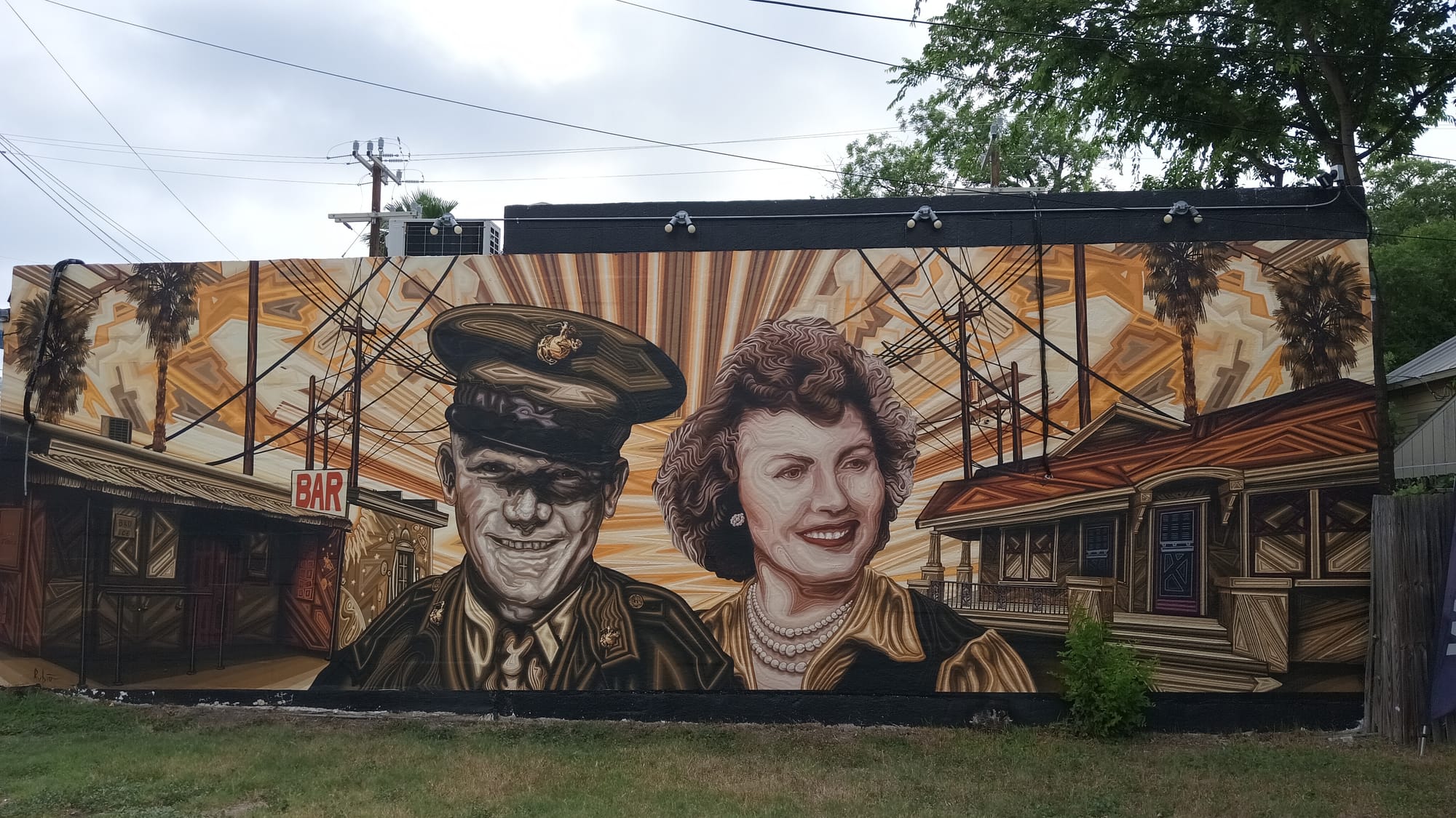 A wall mural of a man in his military uniform with a woman, walking in downtown San Antonio, TX