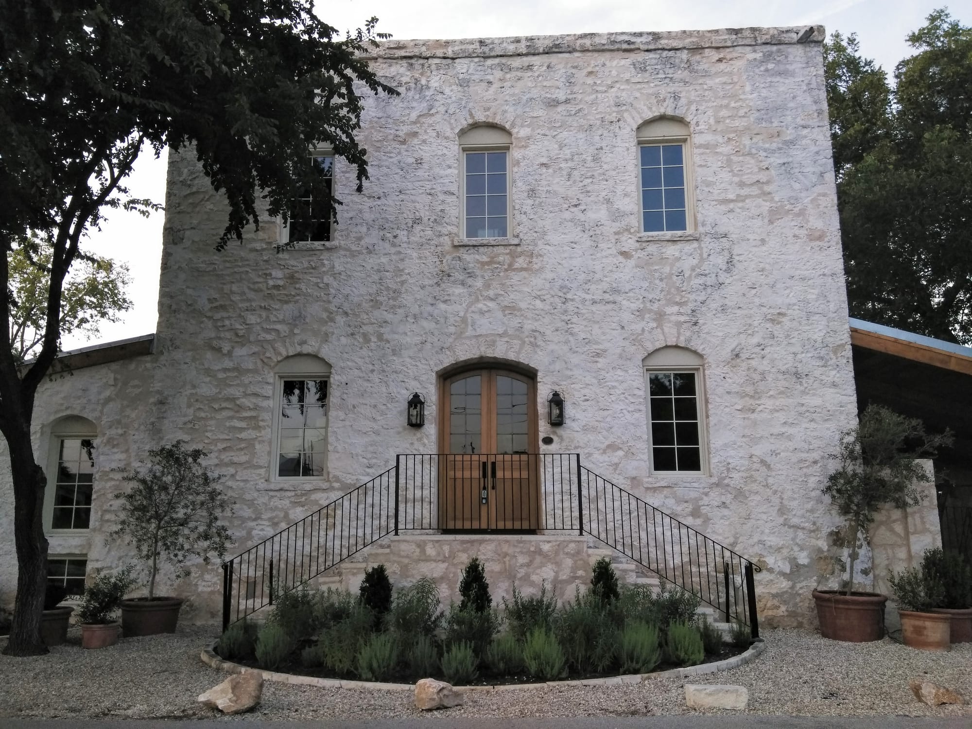 A photo of the front of the historic Gristmill in Valley Mills, TX with a large wood, double entry door