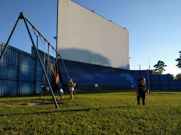 Kids running around at the playground at The Showboat Drive In Movie Theater just north of Houston TX