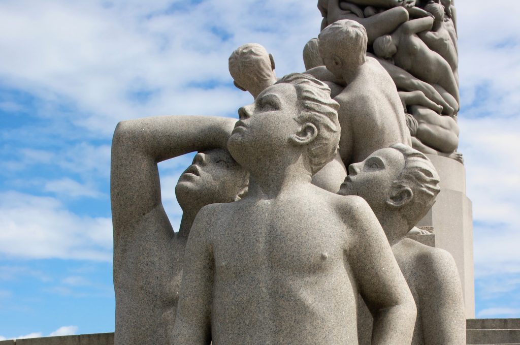 granite carvings of youths looking with hope up to their right; what’s going on up there?
