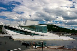 wide-angle shot of modern building with white stone surfaces sloping into the sea