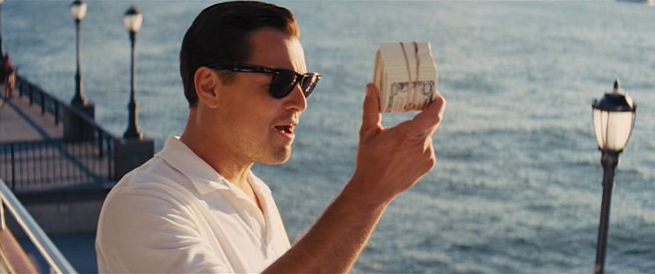 Image of Leonardo Dicaprio holding a roll of cash from the movie Wolf of Wall Street