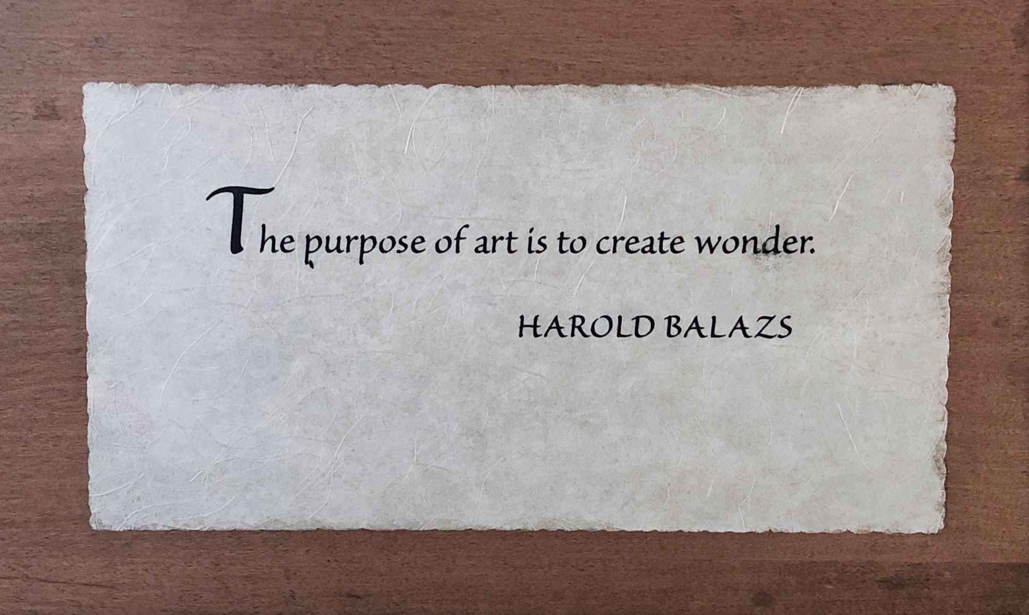 Photo of wooden plaque with Harold Balazs quote: “The purpose of art is to create wonder.”
