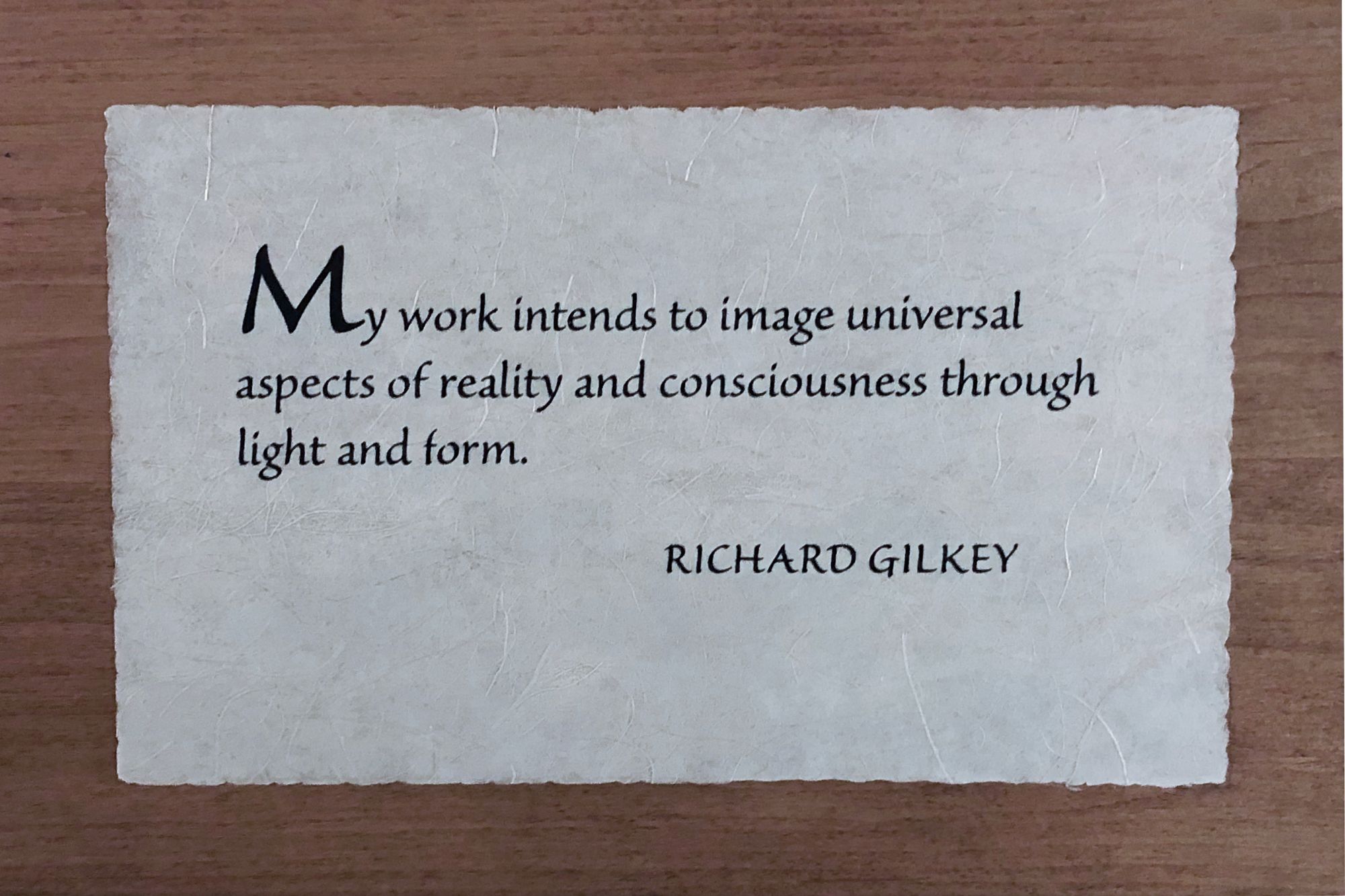Photo of wooden plaque with Richard Gilkey quote: “My work intends to image universal aspects of reality and consciousness through light and form.”