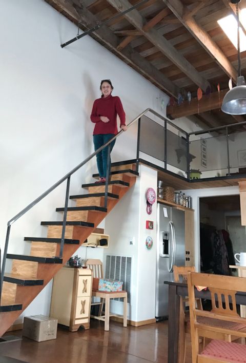 Sandra standing on the stairs in her Tieton Art Loft, December 2016, by David Bilides
