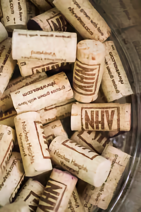 Photo of a pile of corks with the NHV logo on them.