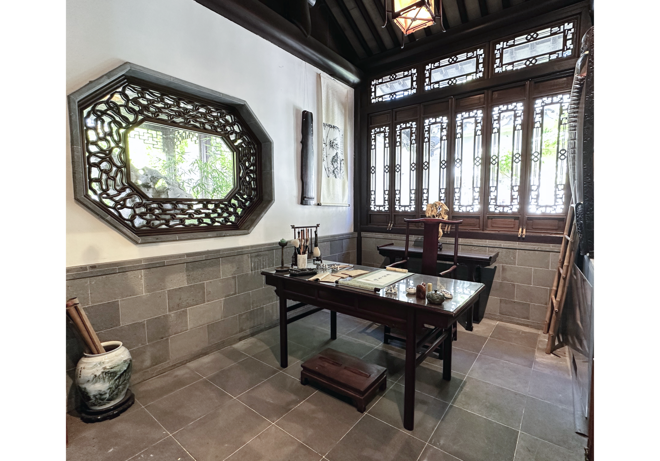 Photo of room with wooden desk, ornate windows and large mirror