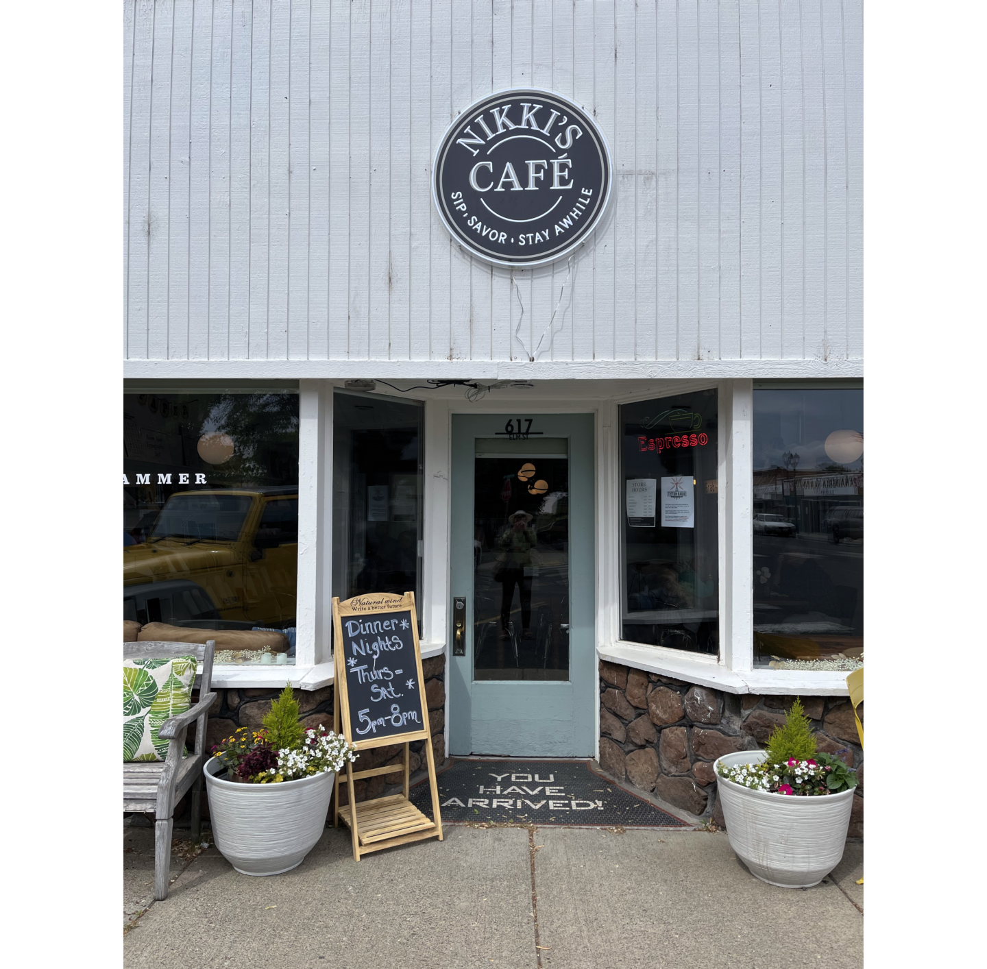 Photo of front of Nikki's Café, with blue door in center and windows on sides