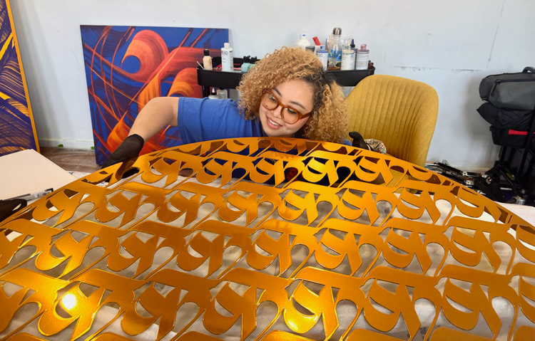 Photo of woman holding golden filigreed sculpture