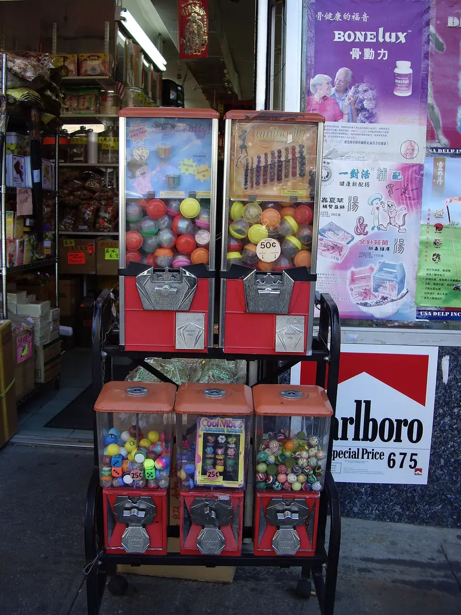 Loose plastic capsule toys in assorted colors spilled together, showing the translucent domes used in gashapon machines