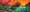 A riverside crane lifts a rusted boiler from clear turquoise water, revealing a ridged riverbed and submerged scrap beneath a vivid orange and pink sky.