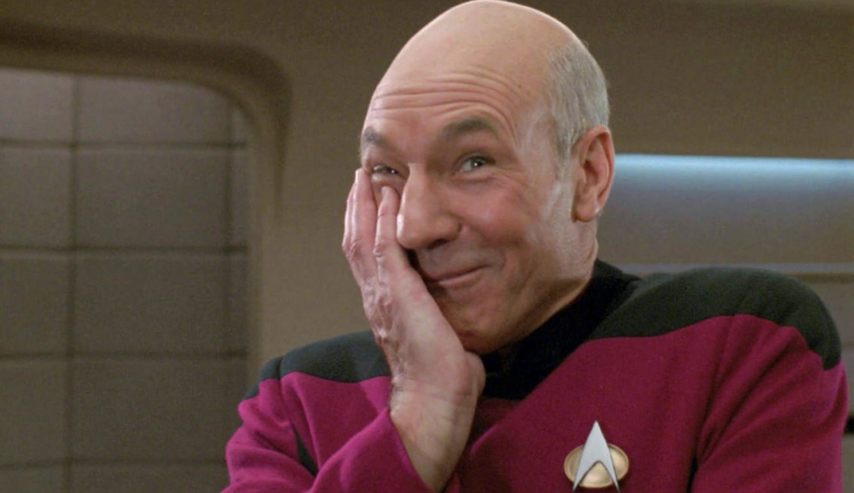 Patrick Stewart as Picard with a laughing smile on his face.