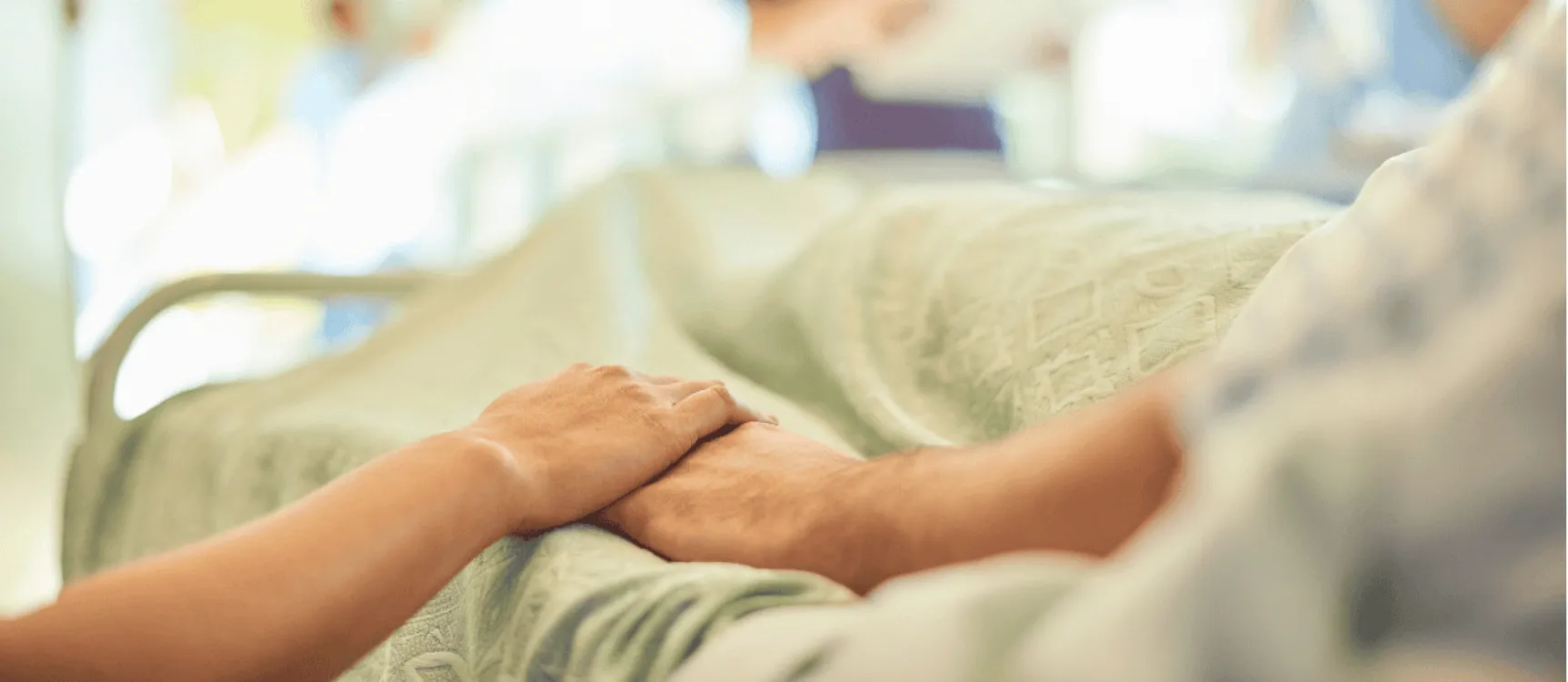 Altenpflegehelferin hält die Hand ihrer Patientin