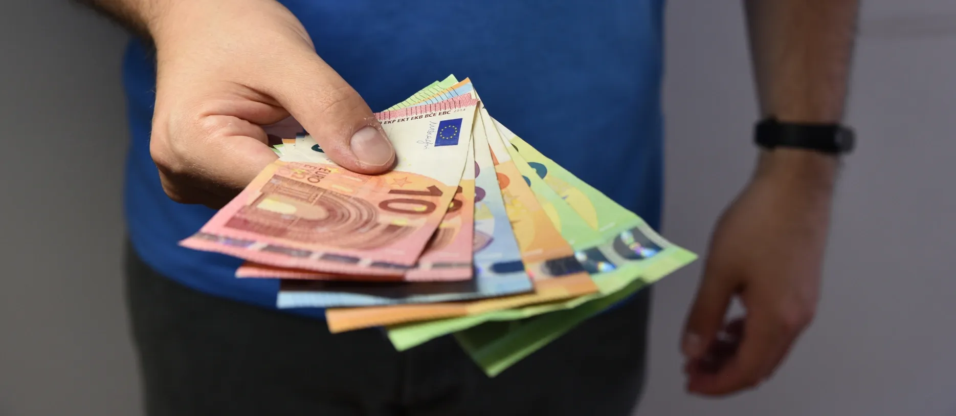 Mann hält Euroscheine in der Hand