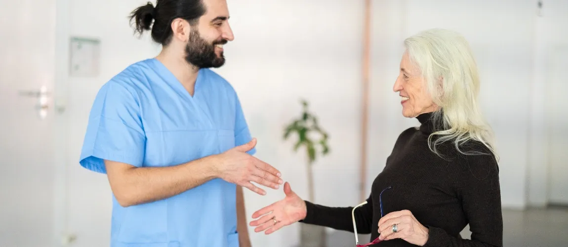 Pflegekraft gibt Patientin die Hand