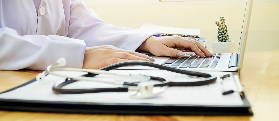 Eine Pflegerin arbeitet in der Verwaltung an einem Laptop statt im Schichtdienst