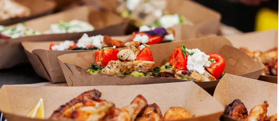 Abbildung verschiedener Snacks in kleinen Pappbehältern. 