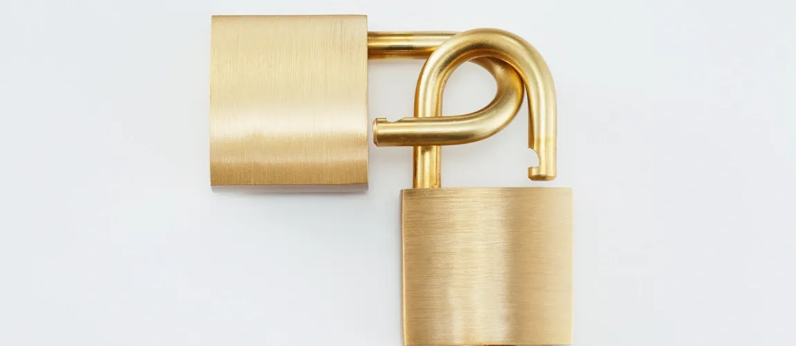 Zwei goldene Schlösser greifen ineinander.