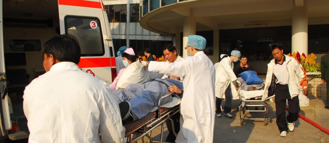 Ärzt:innen und Pflegepersonal kümmern sich vor einem Krankenhaus um mehrere Verletze. 