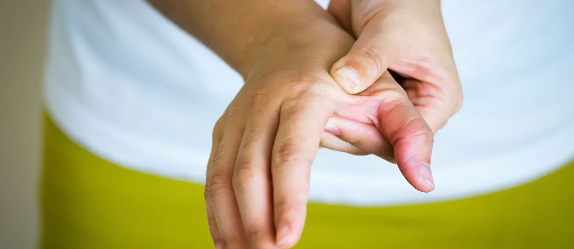 Eine Person drückt mit der einen Hand auf die Oberseite der anderen Hand.