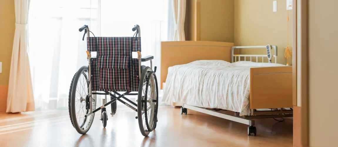 Leerer Rollstuhl in Krankenhauszimmer.