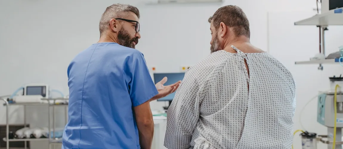 Es ist ein Pfleger mit einem adipösen Patienten zu sehen. 