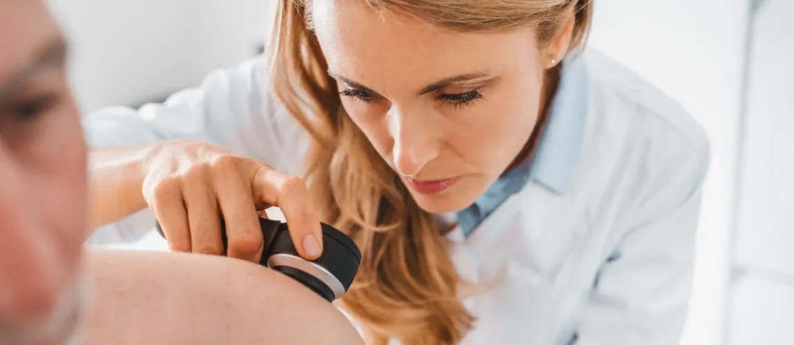 Eine Ärztin untersucht die Haut eines Patienten.