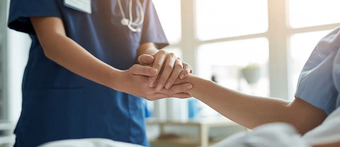 Eine Pflegekraft hält die Hand einer Patientin. 