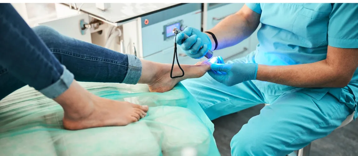 Ein Podologe führt eine Behandlung am Fuß einer Patientin durch. 