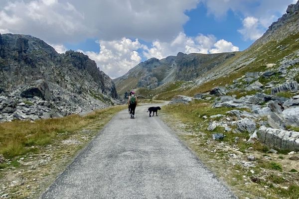 Strada che sale in una valle di montagna tra le rocce, verso le nuvole