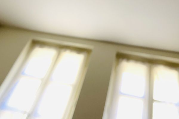 Due finestre luminose viste dal basso, luce calda che entra in una stanza