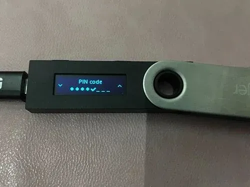 Pantalla del dispositivo Ledger mostrando la PIN ingresada con una marca de verificación y solicitando confirmación nuevamente
